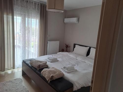 1 dormitorio con 1 cama grande y toallas. en Homing Volos Exclusive Luxury Residence, en Volos
