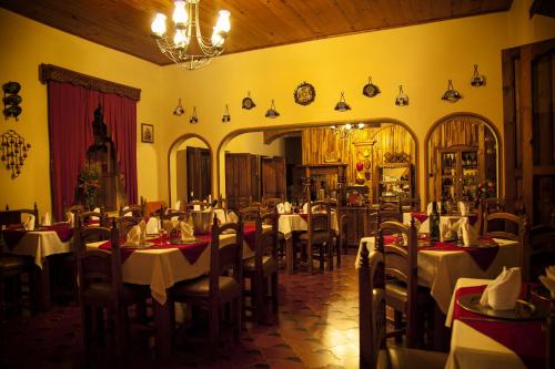 a dining room with tables and chairs and a chandelier at Hotel La Casa de Mamá in San Cristóbal de Las Casas