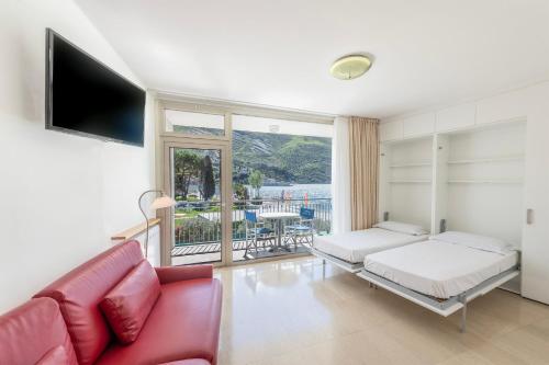 a living room with a red couch and a tv at Residence Casa al Sole Apartments in Nago-Torbole