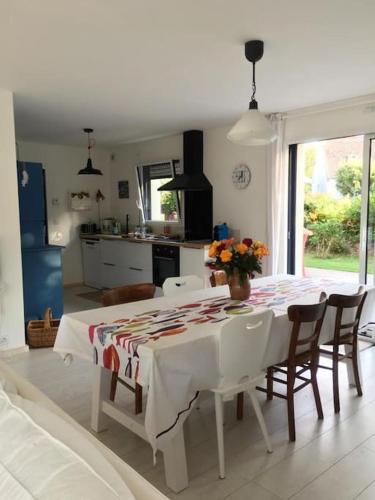 une cuisine et une salle à manger avec une table et des chaises dans l'établissement Maison de vacances à 8 min des plages par un chemin enchanteur, à Fouesnant