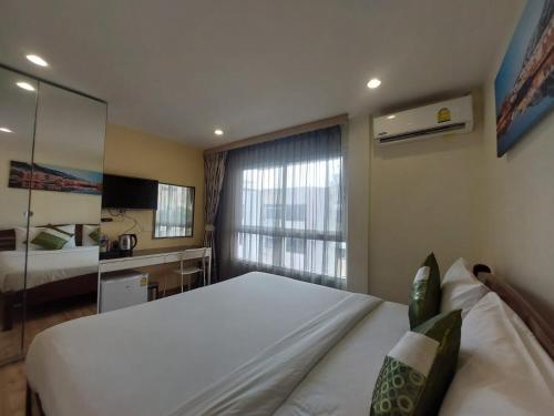 a bedroom with a large white bed and a window at V Check inn Sukhumvit 22 in Bangkok