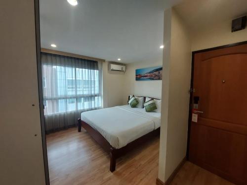 a bedroom with a bed and a large window at V Check inn Sukhumvit 22 in Bangkok