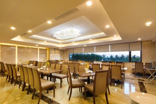 a restaurant with tables and chairs and a large window at Sea Pearl Hotel in Nha Trang