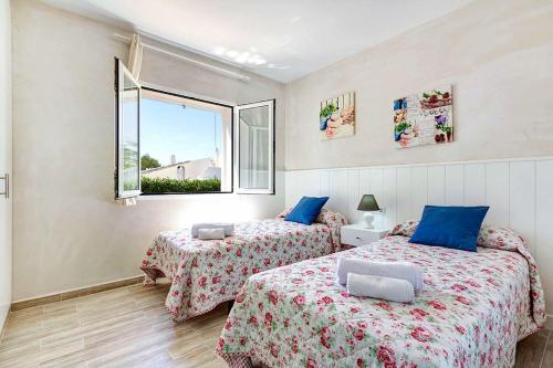 a bedroom with two beds and a window at Villa Ginevra in Son Bou