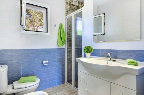 a bathroom with a white sink and a toilet at Villa Ginevra in Son Bou