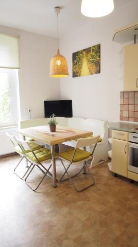 uma mesa de jantar e cadeiras numa cozinha em Apartamenty Hotelique em Sopot