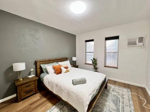 um quarto com uma cama grande e 2 janelas em Immaculate Stylish Apartment em South Hedland
