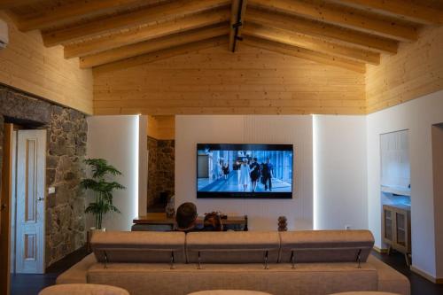 a living room with a large couch and a flat screen tv at Casa Gondiga in Roriz