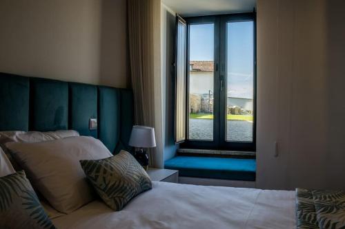 a bedroom with a bed and a large window at Casa Gondiga in Roriz