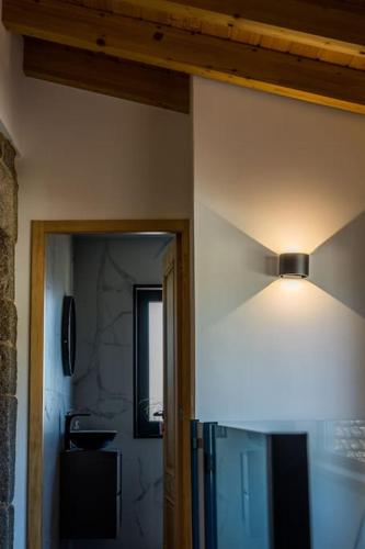 a room with a light on the wall and a bathroom at Casa Gondiga in Roriz