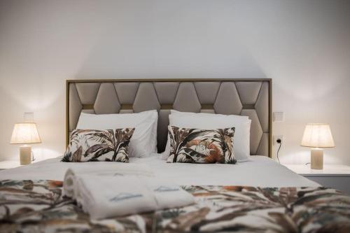 a large bed with two lamps and two pillows at Casa Gondiga in Roriz