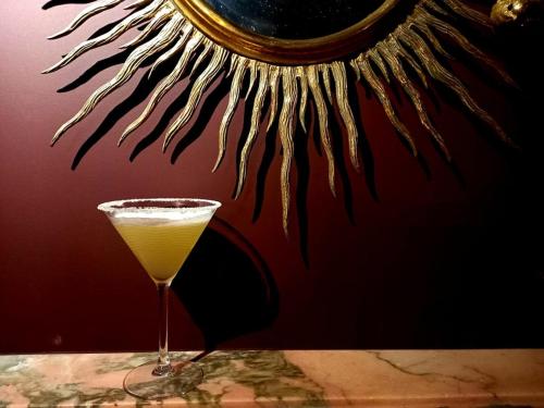 a drink in a glass sitting on a table at Chambre aux Miroirs - Love Room - La Vénus de Lisbonne in Calhandriz