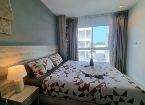 a bedroom with a bed and a large window at Grandblue condominium 106,302 in Mae Pim
