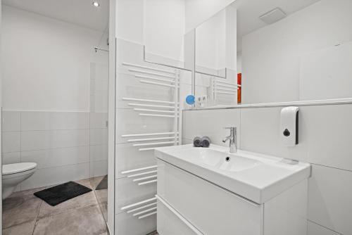 bagno bianco con lavandino e servizi igienici di Sara a Friedrichshafen