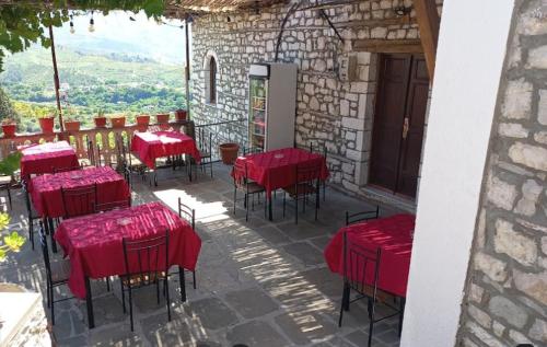 a restaurant with red tables and chairs on a patio at Villa Kokoshi, an extraordinary experience. in Berat