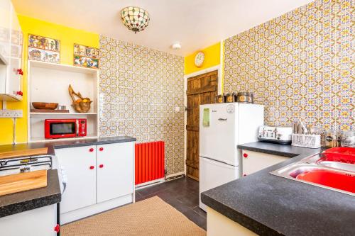 a kitchen with a white refrigerator and a sink at Pirate Cottage Penryn Falmouth families & couples in Penryn
