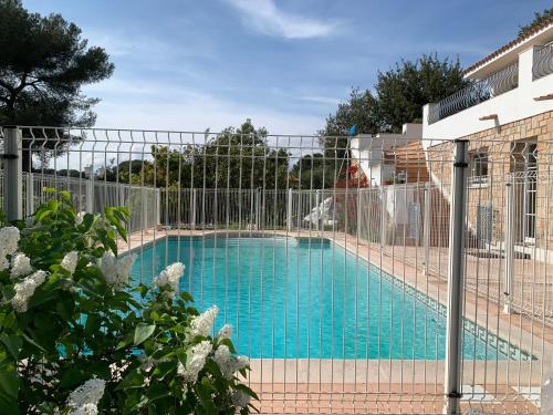 ein Schwimmbad mit einem Zaun um ihn herum in der Unterkunft Maison de ville dans la Villa Brise des Pins in Le Cannet