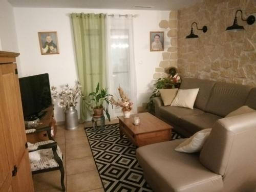 a living room with a couch and a tv at The happy house in Le Martinet