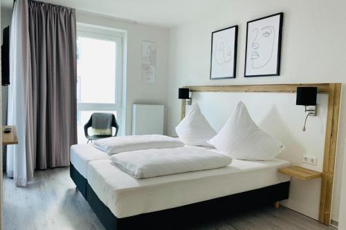 a bedroom with a bed with white sheets and pillows at Fewo 3-13 Ostsee in Kappeln