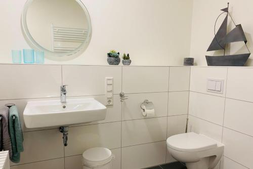 a bathroom with a sink and a toilet and a mirror at Fewo 3-13 Ostsee in Kappeln