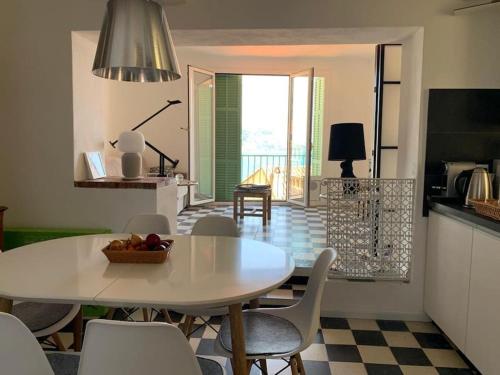 een keuken en eetkamer met een tafel en stoelen bij Villa Capodanna, au coeur de la vieille ville, maison de village avec magnifique vue sur la mer in Menton