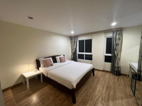 a bedroom with a large bed and two windows at V Check inn Sukhumvit 22 in Bangkok