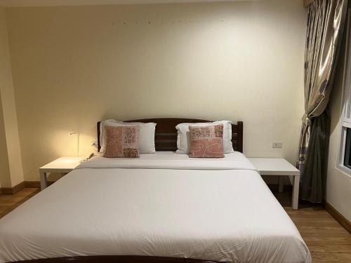 a bedroom with a large white bed with pillows at V Check inn Sukhumvit 22 in Bangkok