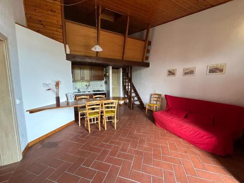 a living room with a red couch and a kitchen at Residence San Francesco in Pomarance