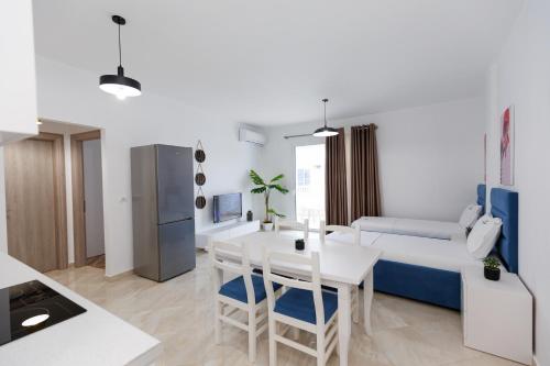 a kitchen and living room with a white table and chairs at CAPTAIN'S RESIDENCE in Ksamil