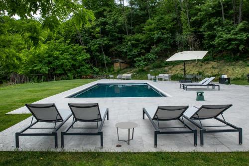 a pool with chairs and a table and an umbrella at Cruna di Subida Wine Country House in Cormòns