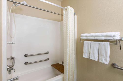 ein Badezimmer mit einer Dusche, einer Badewanne und Handtüchern in der Unterkunft Super 8 by Wyndham Ottawa in Ottawa