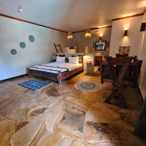 a bedroom with a bed and a desk in a room at Mambo Cabana in Pwani Mchangani