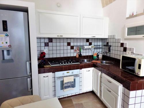 a kitchen with white cabinets and a stove top oven at Regina Viarum Apartment, Historic City Centre in Brindisi