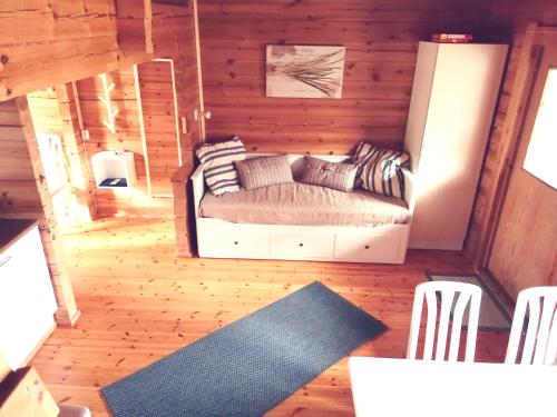 a living room with a couch in a log cabin at Isotalo Farm at enäjärvi lake in Salo