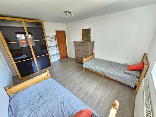 - une petite chambre avec 2 lits et une commode dans l'établissement entire 2 bed Apartment Jasmine fully serviced, à Elmers End