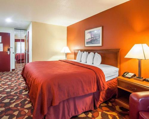 a hotel room with a bed and a phone at Quality Inn & Suites Kansas City I-435N Near Sports Complex in Kansas City