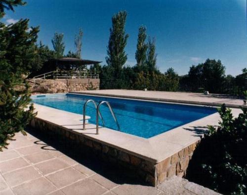 a large swimming pool in a yard with at Cabañas Rústicas dentro de la Finca El Castillo in La Cabrera