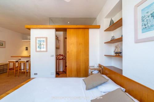 a bedroom with a white bed and a kitchen at Seaview Open Space Loft by PortofinoVip in Portofino
