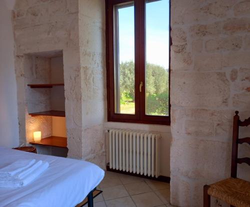 1 dormitorio con cama y ventana en Torre Marinella, en Ostuni