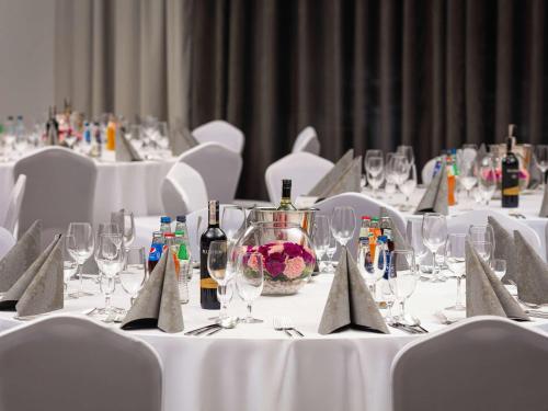 a group of tables with wine bottles and glasses at Mercure Warszawa Ursus Station in Warsaw
