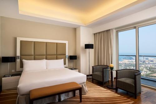 a hotel room with a bed and a large window at La Suite Dubai Hotel & Apartments in Dubai
