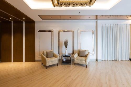 a room with two chairs and a table and a chandelier at Best Western Plus Metro Clark in Angeles