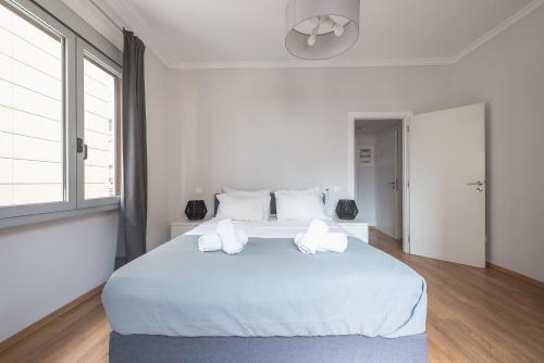 una camera da letto bianca con un grande letto bianco con cuscini bianchi di Syntagma SQ Residence ad Atene
