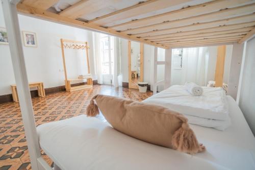 a bedroom with two white beds and a wooden ceiling at Casa de la Alegría in Granada