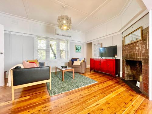 a living room with a couch and a fireplace at Barton Cottage in Katoomba