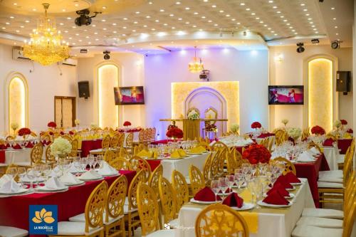 a banquet hall with white tables and yellow chairs at LA ROCHELLE HOTEL in Yaoundé