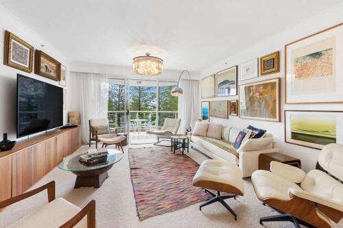 a living room with a couch and a tv at Oscar on Main resort Walk to beach and Tedder Ave in Gold Coast