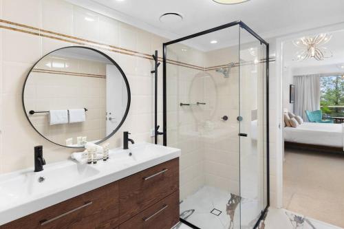 a bathroom with a shower and a sink and a mirror at Oscar on Main resort Walk to beach and Tedder Ave in Gold Coast