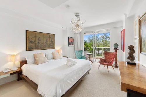 a white bedroom with a large bed and a desk at Oscar on Main resort Walk to beach and Tedder Ave in Gold Coast