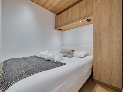 a bedroom with a white bed and wooden walls at Appartement Tignes, 2 pièces, 4 personnes - FR-1-641-17 in Tignes